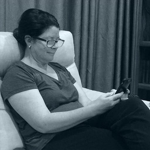 A volunteer Chatloop partner sitting in an armchair sending and reading text messages