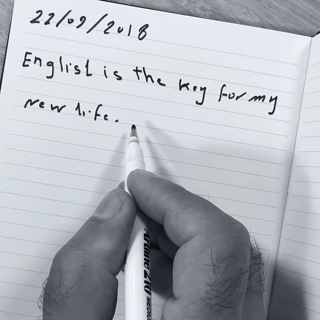 Somebody from a refugee background handwriting 'English is the key to my new life.'